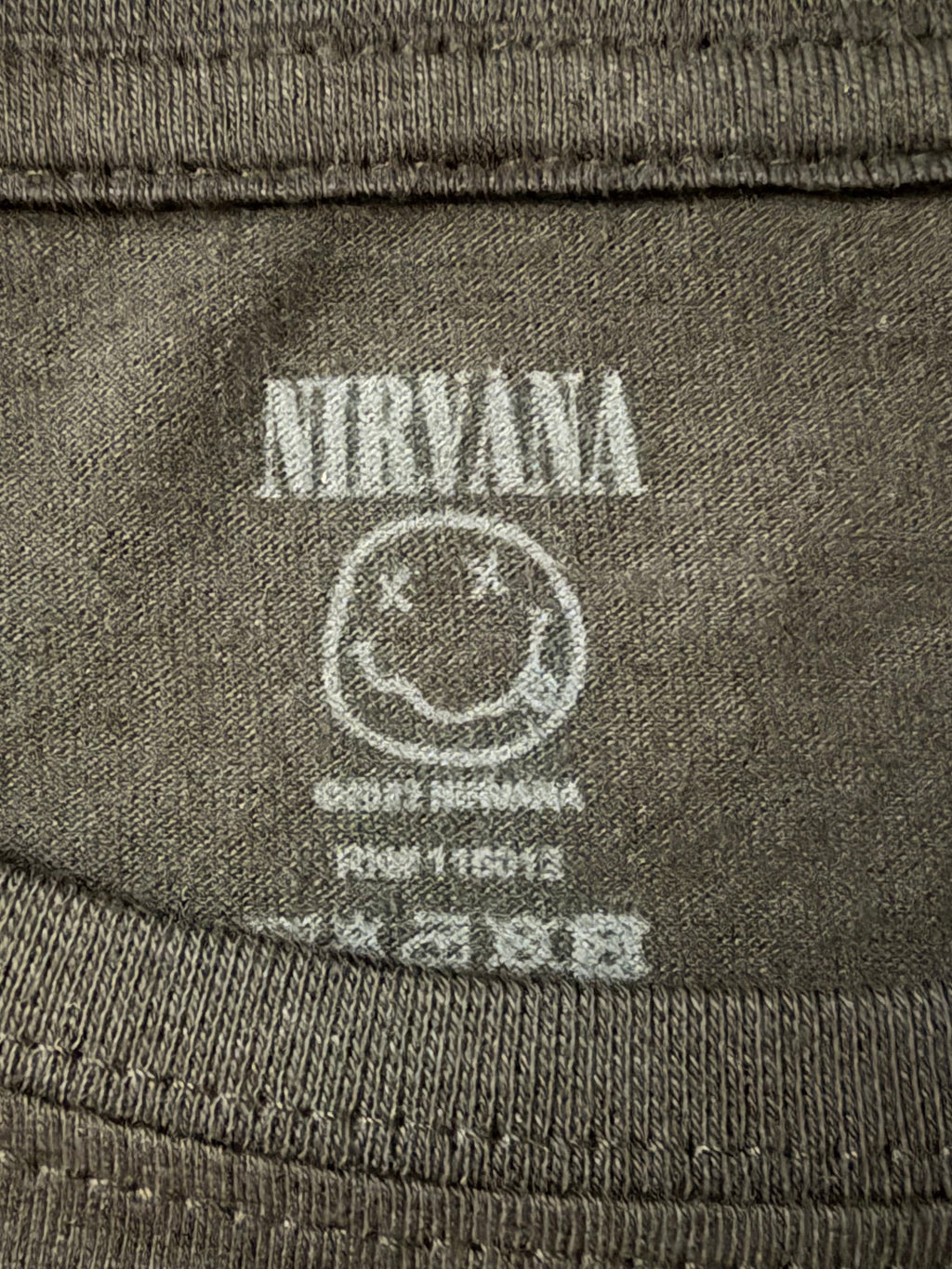 Macro detail of the screen-printed inner neck tag on the official black AC/DC short-sleeve t-shirt showing size and registration information.