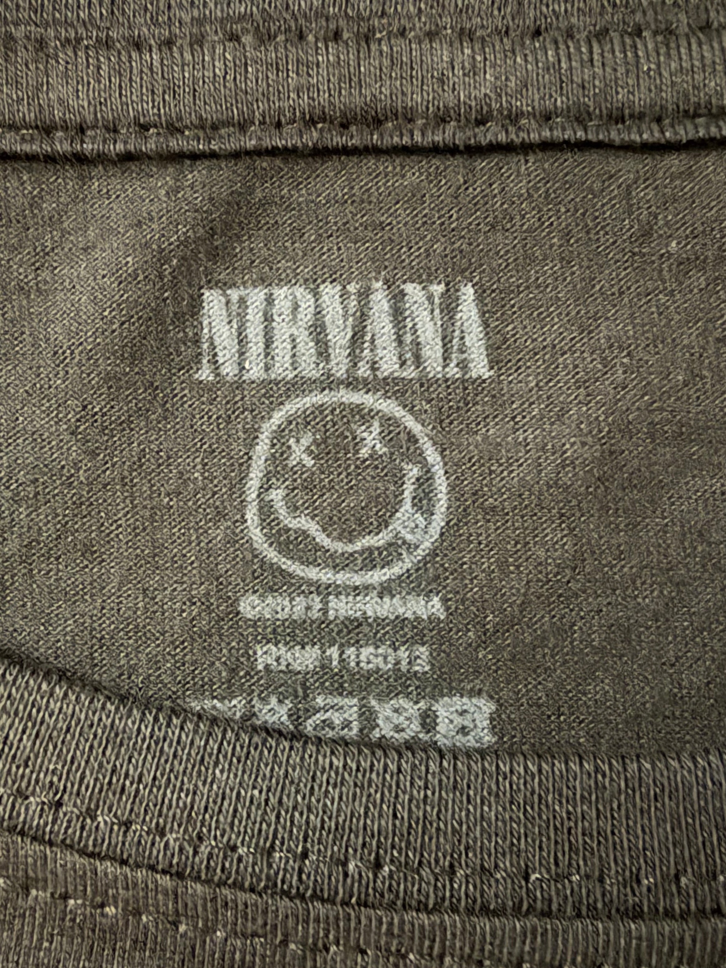 Macro detail of the screen-printed inner neck tag on the official black AC/DC short-sleeve t-shirt showing size and registration information.