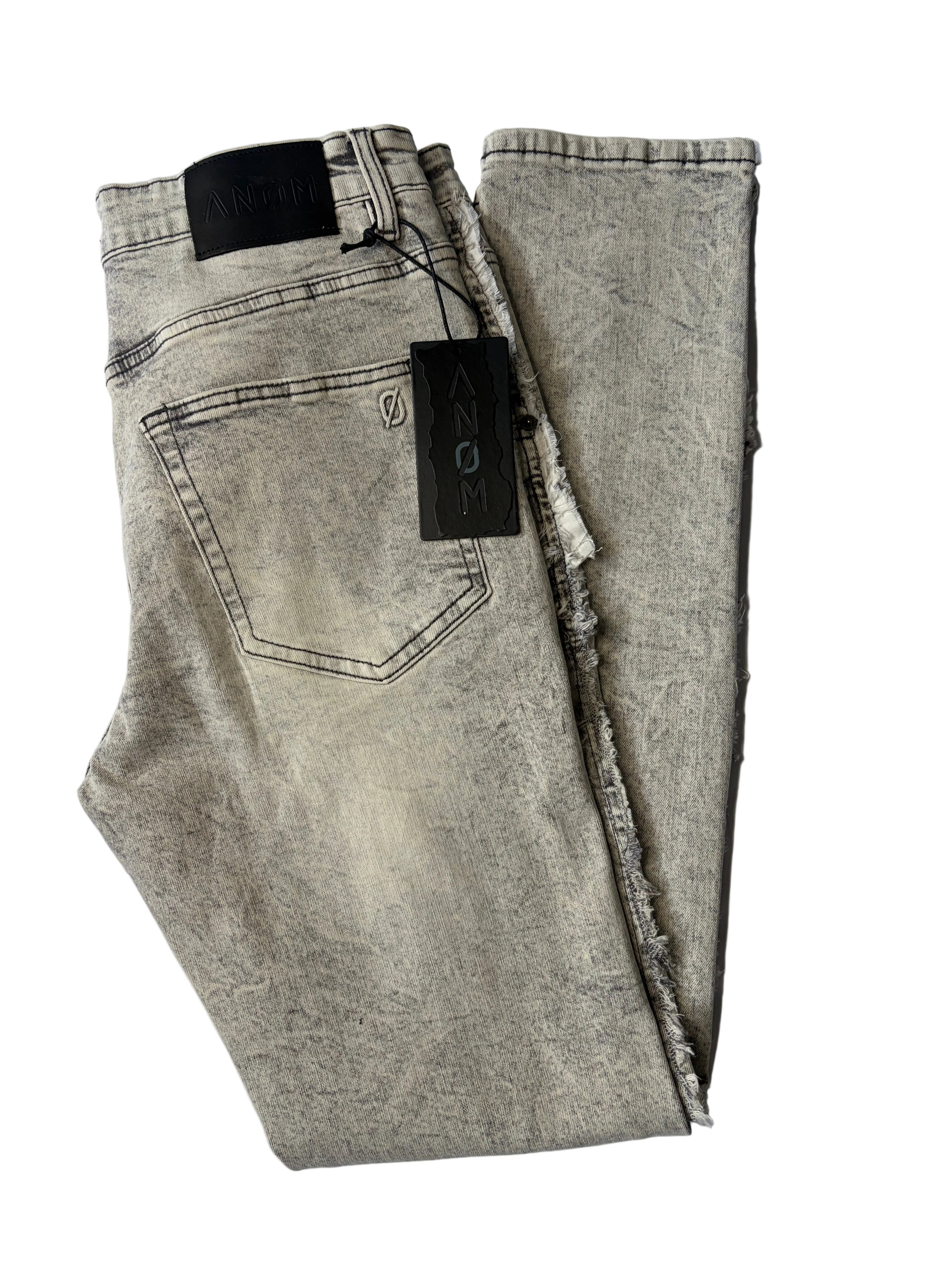 Alternate back layout of AMNÉ modern streetwear denim jeans in a textured grey acid wash. Displays heavily distressed frayed side seams, a signature black leather logo patch, and branded hang tags.