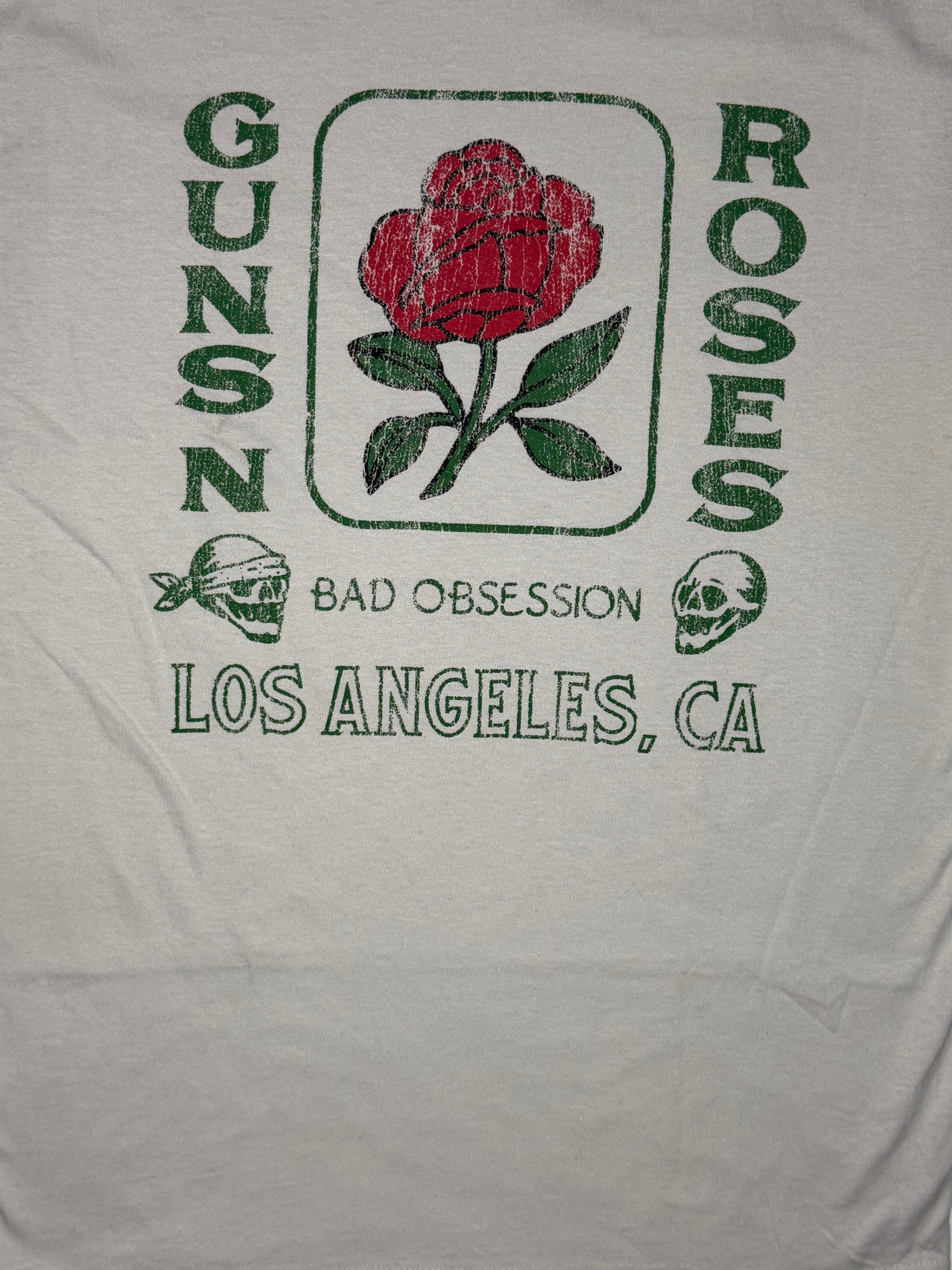 Official licensed Guns N' Roses stone-colored T-shirt featuring a red rose graphic with Bad Obsession and Los Angeles California typography.