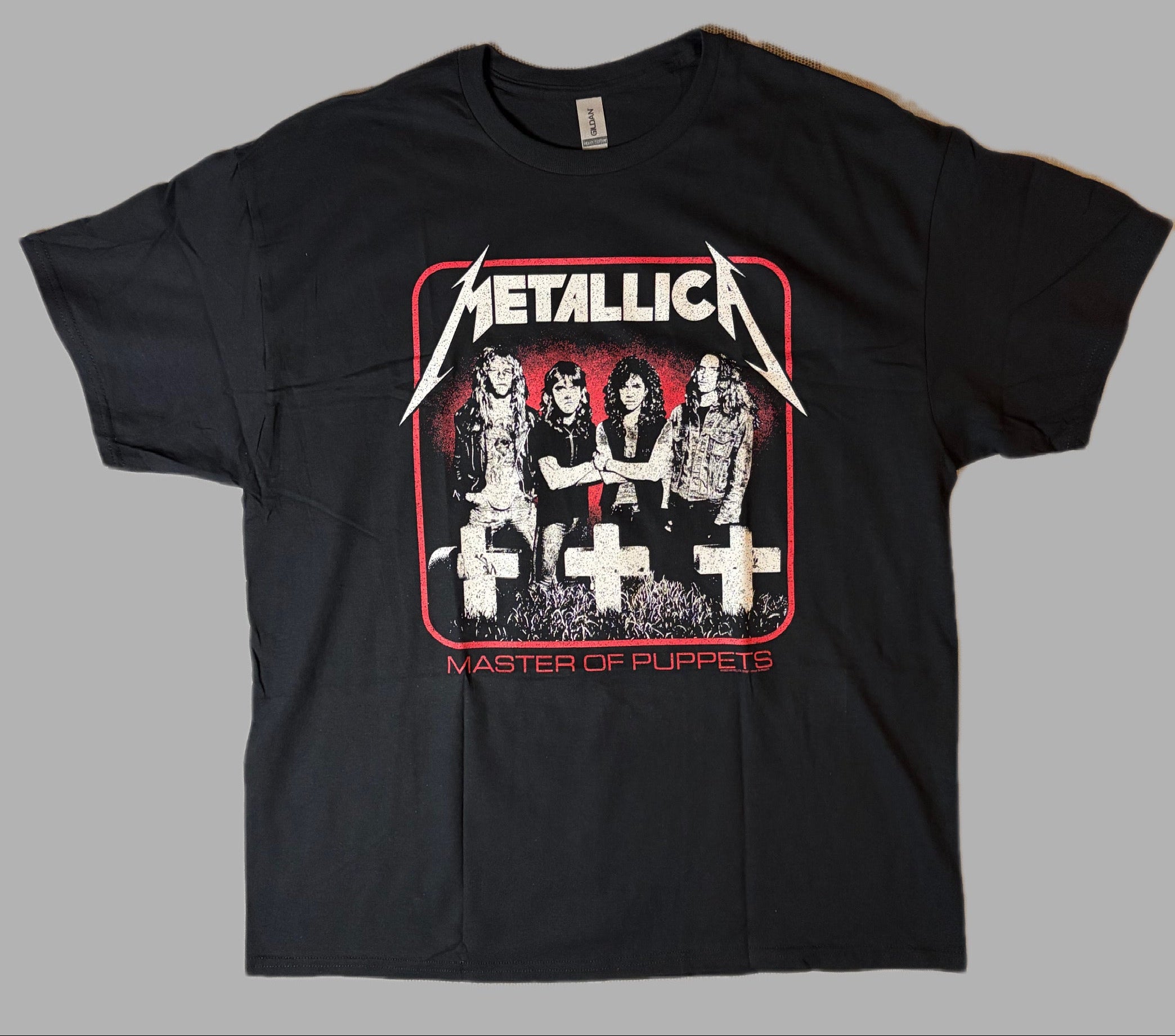 Front view of an official licensed Metallica unisex short-sleeve graphic t-shirt in black featuring the vintage Master of Puppets band photo and graveyard crosses artwork.