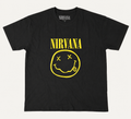 Front flat lay view of an official licensed Nirvana unisex black graphic t-shirt featuring the classic Kurt Cobain yellow smiley face logo and arched band spellout text.