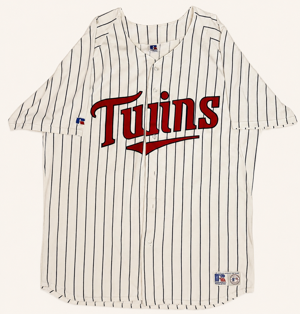 Front view of vintage mid-1990s Minnesota Twins MLB white button-up baseball jersey with midnight navy pinstripes and layered red tackle-twill script chest logo by Russell Athletic