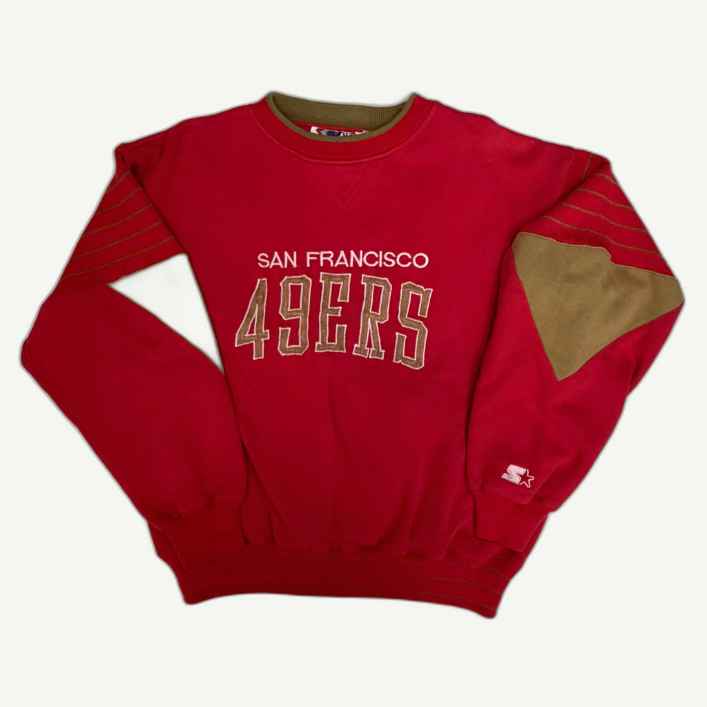 Front view of vintage mid-1990s San Francisco 49ers NFL heavyweight red crewneck sweatshirt with ribbed knit drop-shoulder stripes, metallic gold paneling, and direct-embroidered tackle-twill chest spellout by Starter