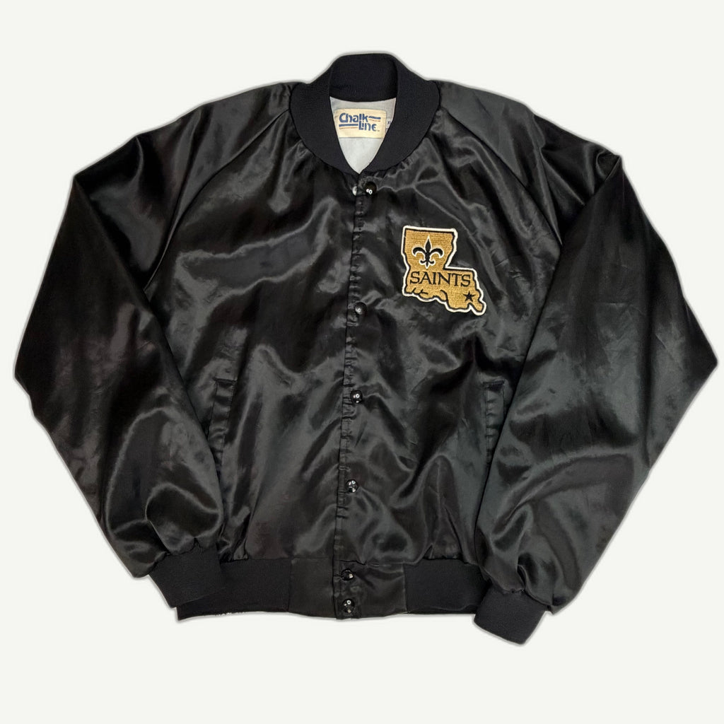 Front and back view of vintage 1980s New Orleans Saints NFL black nylon satin varsity jacket with chenille Louisiana state patch by Chalk Line